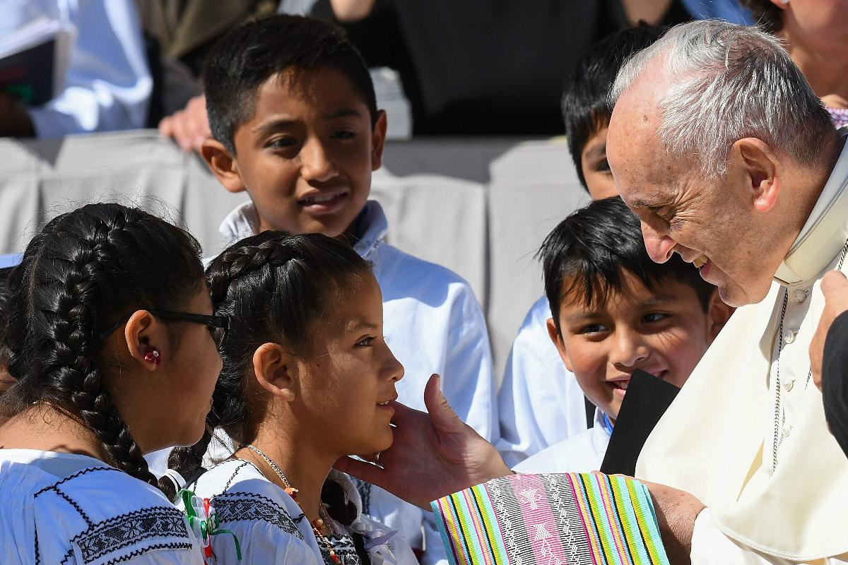 O Papa Francisco recebendo presentes de crianças mexicanas no final de sua audiência geral semanal na praça de São Pedro, no Vaticano, na manhã desta quarta-feira (20) | VINCENZO PINTO/AFP