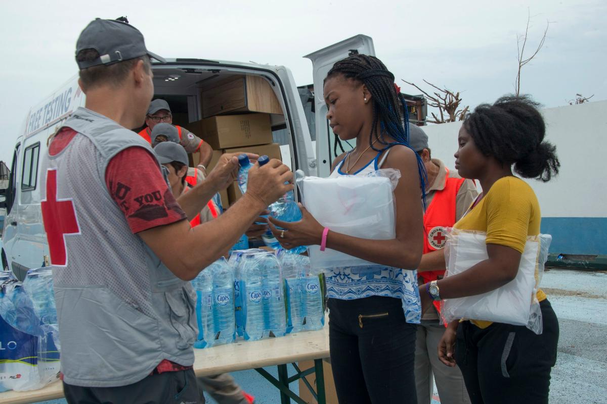 Voluntários da Cruz Vermelha distribuem água para a população na ilha de Saint-Martin | HELENE VALENZUELA/AFP