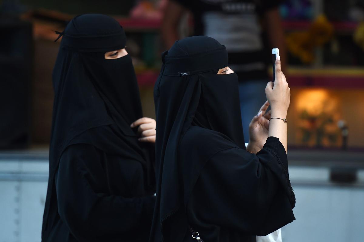 Mulheres caminham pela rua Tahlia, na capital saudita, em 24 de setembro de 2017, durante as comemorações do aniversário da fundação do reino. | FAYEZ NURELDINE/AFP
