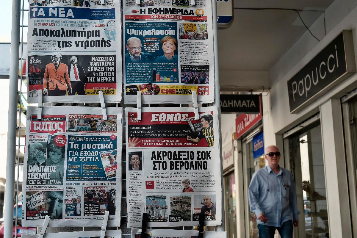 Capas de jornais gregos mostram resultado das eleições na Alemanha | LOUISA GOULIAMAKI/AFP