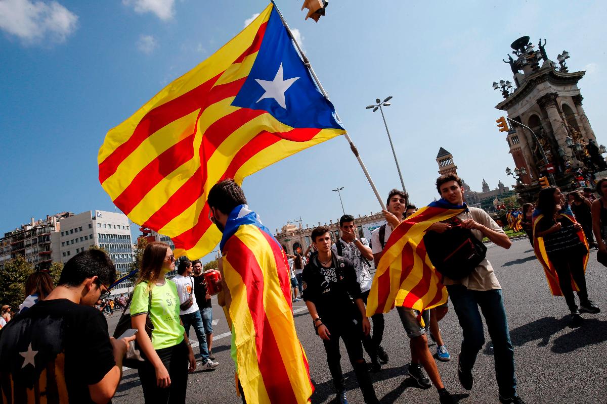 Estudantes erguem bandeira pró-independência Catalunha durante a manifestação | PAU BARRENA/AFP