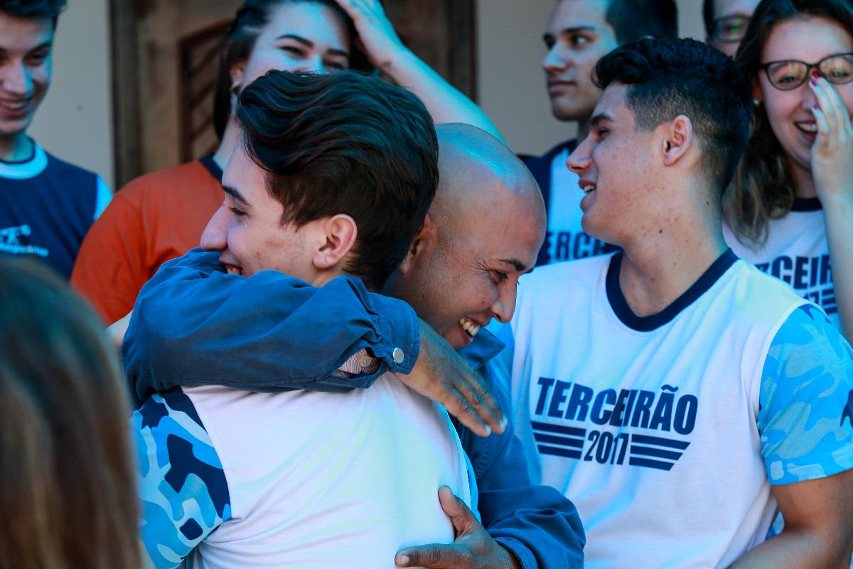 O venezuelano Julio Bernal Galindo e alunos de colégio de Curitiba, após a chegada dos familiares do imigrante ao Brasil, com ajuda da turma | Jonathan Campos/Gazeta do Povo