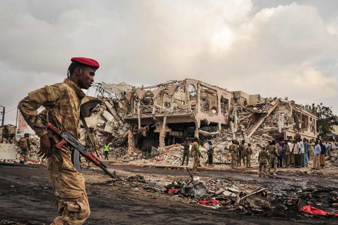 Soldado somali patrulha em meio aos destroços deixados pelo ataque terrorista no centro de Mogadíscio, Somália, em 15 de outubro | MOHAMED ABDIWAHAB/AFP