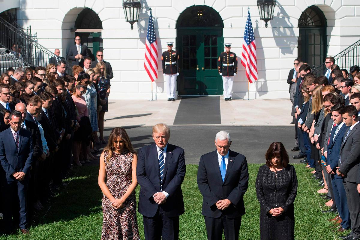 O presidente dos EUA, Donald Trump, e a primeira-dama, Melania Trump, juntamente com o vice-presidente, Mike Pence, e sua esposa, Karen Pence, participam de um momento de silêncio para as vítimas dos tiroteios de Las Vegas, na Casa Branca | SAUL LOEB/
AFP