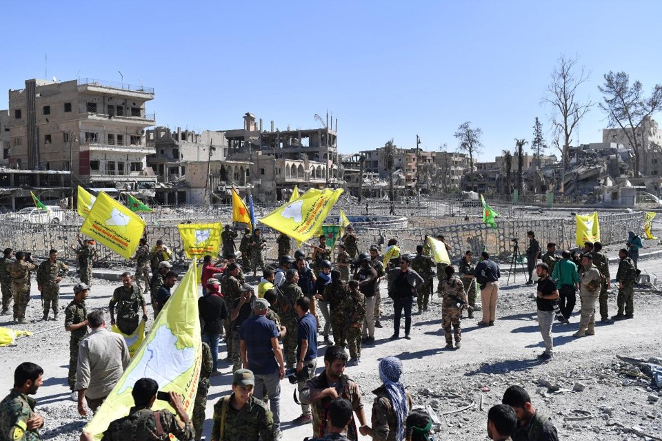 Membros das Forças Democráticas da Síria (SDF), apoiados por forças especiais dos EUA, se reúnem na icônica praça Al-Naim, em Raqqa | BULENT KILIC/AFP