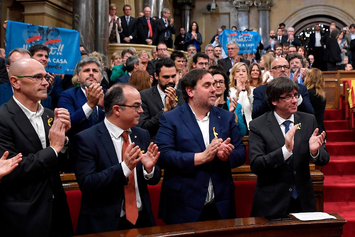 O presidente da Catalunha, Carles Puigdemont, ao lado de seus aliados, Oriol Junqueras, Jordi Turull e Raul Romeva, após a aprovação da resolução sobre a independência | LLUIS GENE/AFP