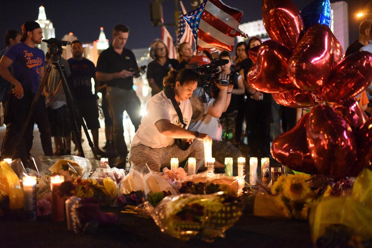 Amigos e familiares acendem velas em um memorial próximo ao hotel Mandalay Bay, em Las Vegas | ROBYN BECK/AFP