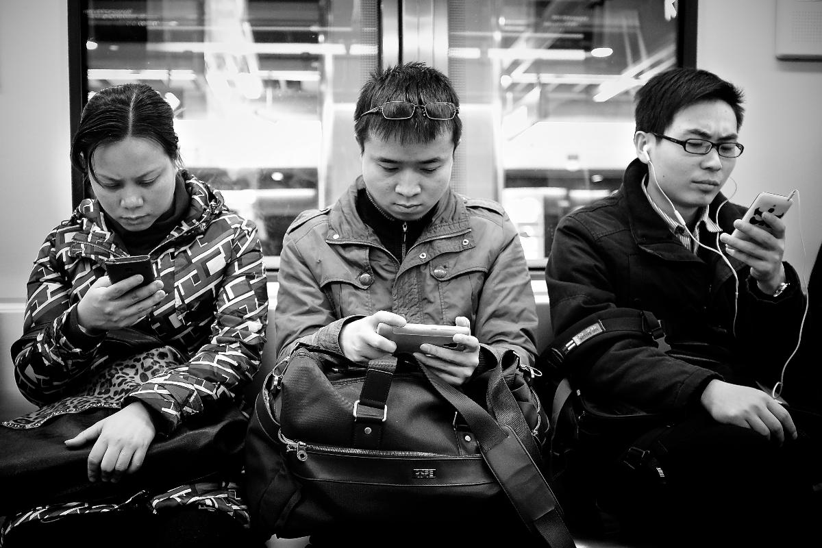 Chineses consultam o smartphone em trem. | Pxhere