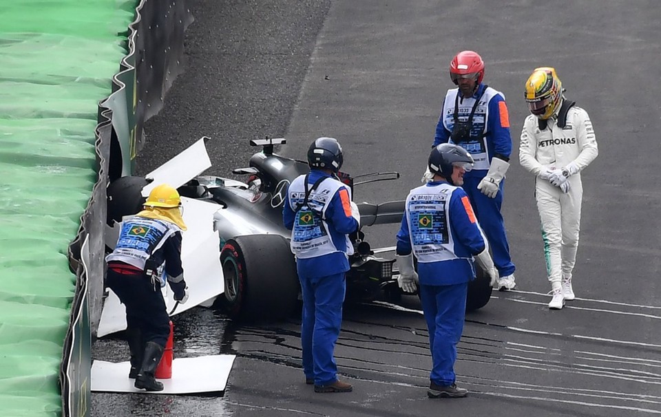 Lewis Hamilton observa o carro destruído após sair na curva e bater contra a proteção de pneus no treino classificatório. | Nelson Almeida/AFP
