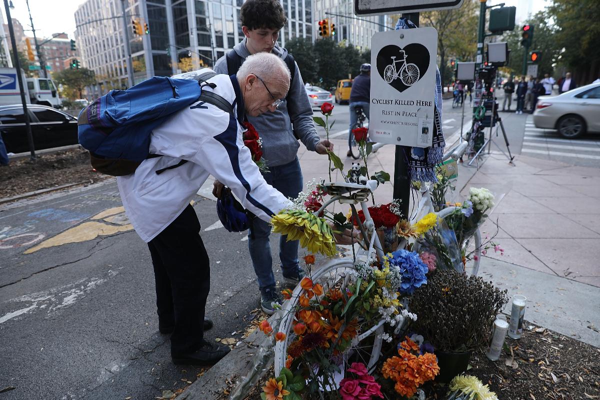Pessoas deixam flores no local onde ciclistas morreram após ataque terrorista em Nova York | SPENCER PLATT/AFP