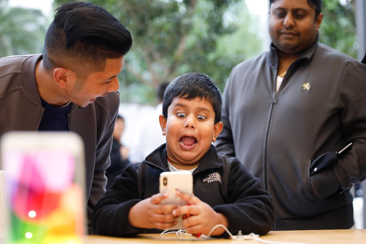 Menino brinca com a câmera frontal do iPhone X em Apple Store de San Francisco, Califórnia. | Elijah Nouvelage/AFP