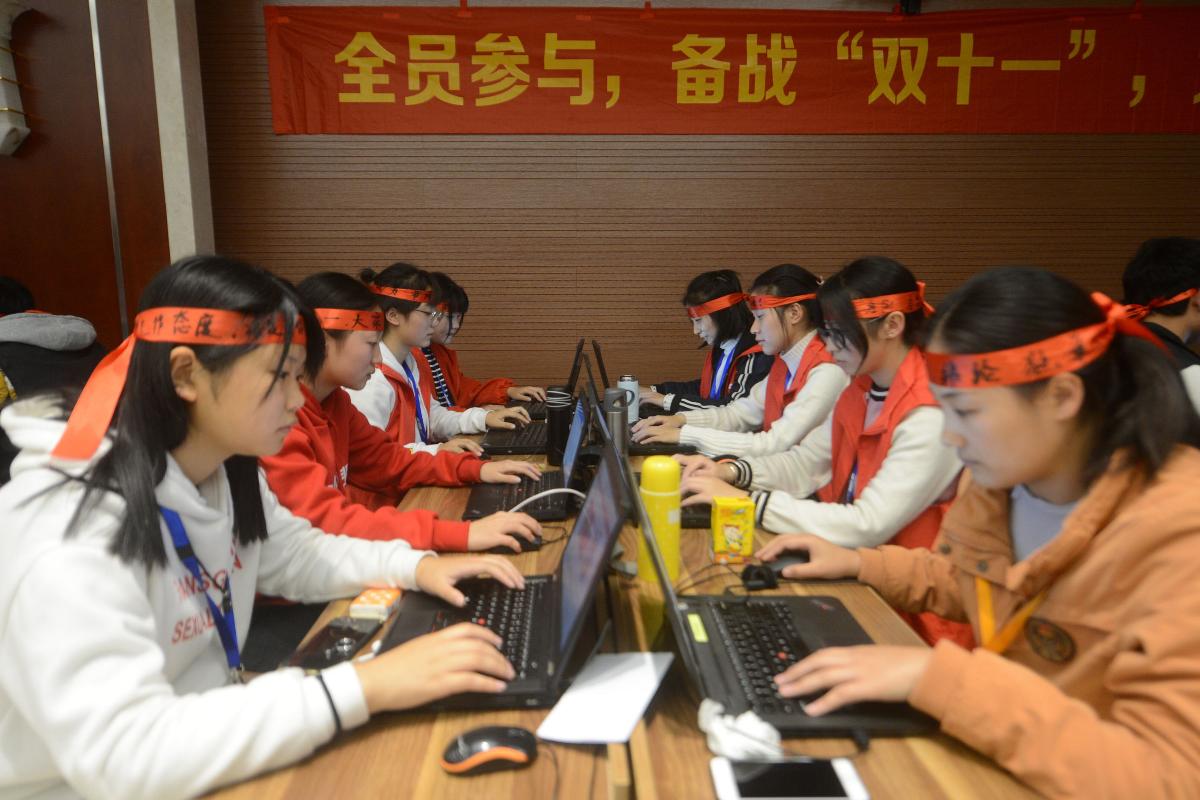 Funcionários de um e-commerce de Yangzhou, da província de Jiangsu, trabalham durante o Single’s Day. | STR/AFP