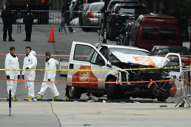 Investigadores trabalham em torno dos destroços da caminhonete do Home Depot utilizada no ataque terrorista em Nova York no dia 31 de outubro de 2017 | JEWEL SAMAD/AFP