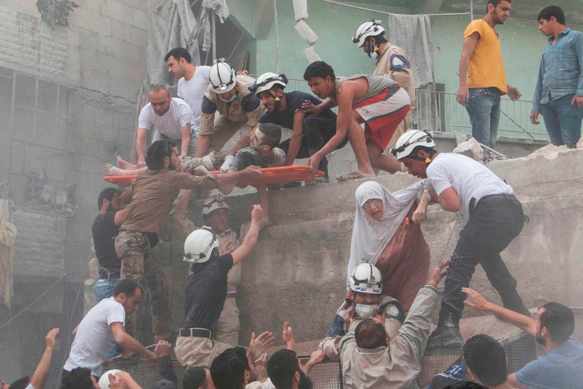 Voluntários durante resgate de cidadãos sírios após um confronto com o Estado Islâmico no distrito central de Al-Fardous | KARAM AL-MASRI/AFP
