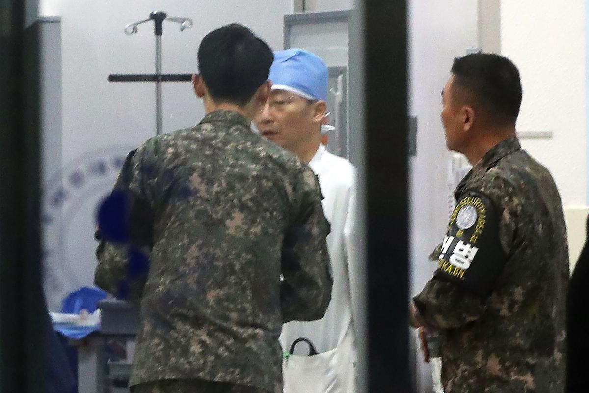 Oficiais militares sul-coreanos conversam com um médico em um hospital em Suwon, sul de Seul | STR/
AFP