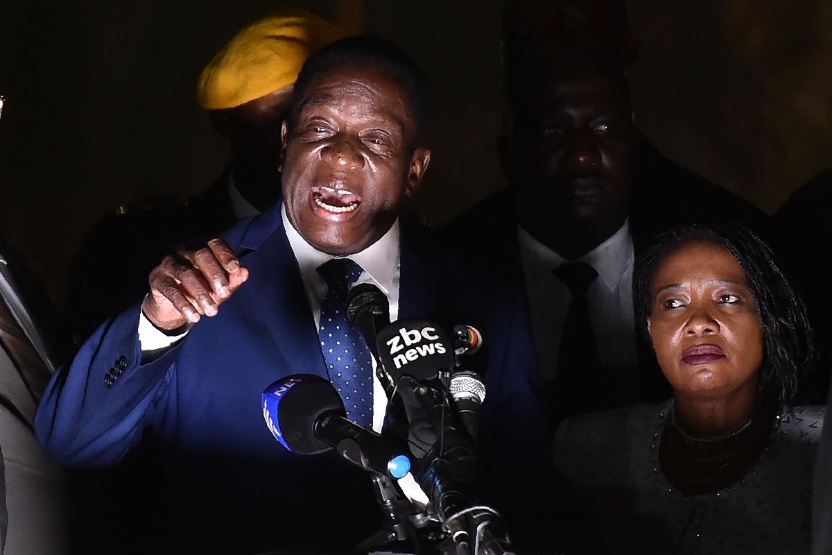 O novo presidente do Zimbabwe, Emmerson Mnangagwa, discursa acompanhado de sua esposa, Auxilia, na sede do partido Zanu-PF, em Harare, Zimbábua, em 22 de novembro de 2017 | TONY KARUMBA/AFP