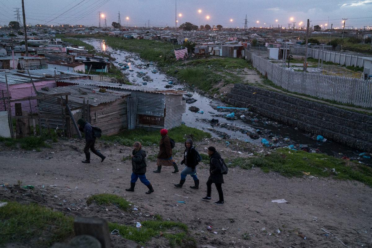 Sul-africanos a caminho de trabalho em Khayelitsha, um município a cerca de 25 quilômetros de distância da Cidade do Cabo | JOAO SILVA/NYT