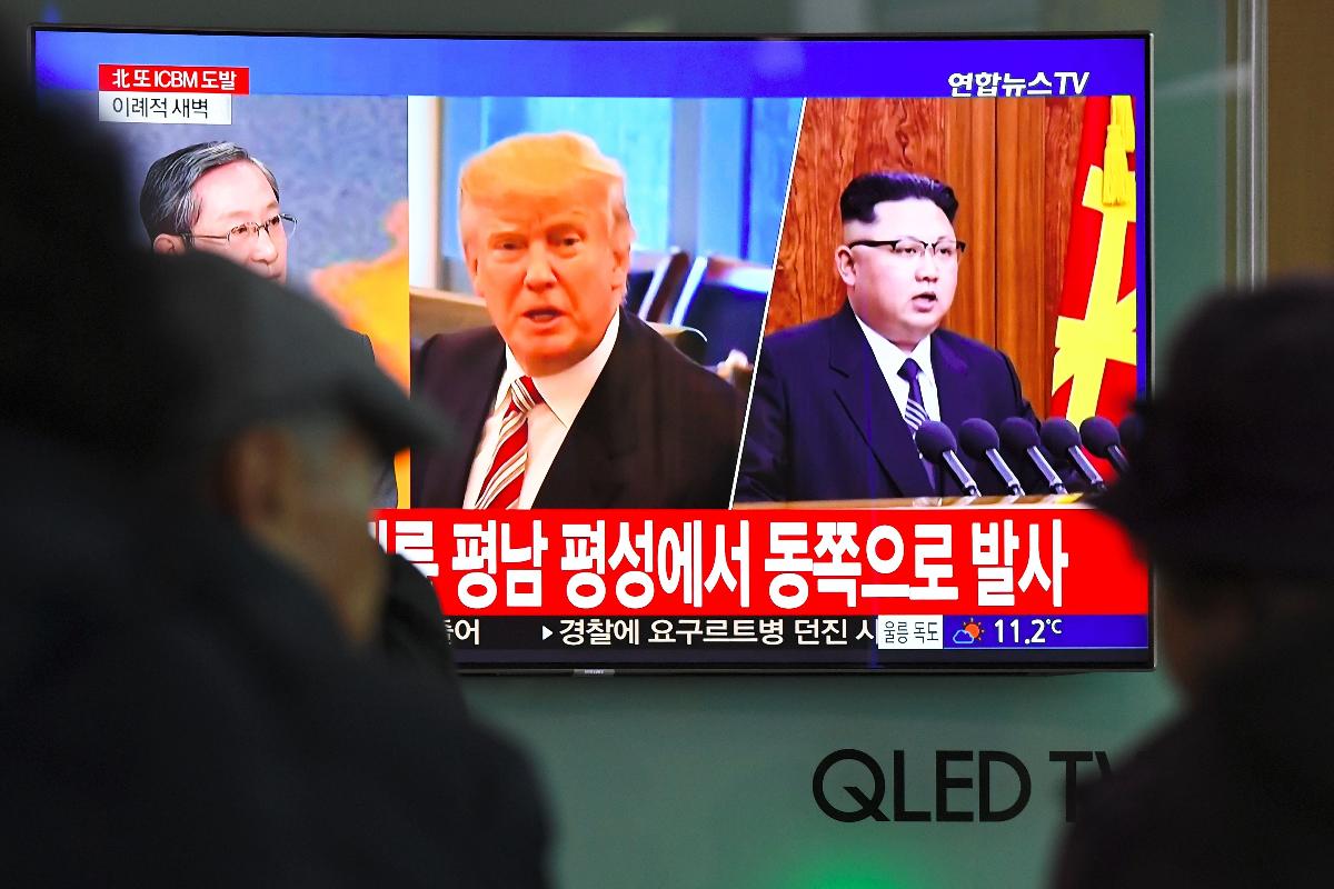 Pessoas veem notícia envolvendo o presidente dos Estados  Unidos, Donald Trump, e líder norte-coreano, Kim Jong-un: impasse entre países continua | JUNG YEON-JE/
AFP