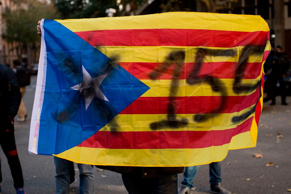 Na imagem, manifestante carrega bandeira da Catalunha em protesto contra o uso do artigo 155 da Constituição espanhola, que tirou poderes do governo regional | JOSEP LAGO/AFP