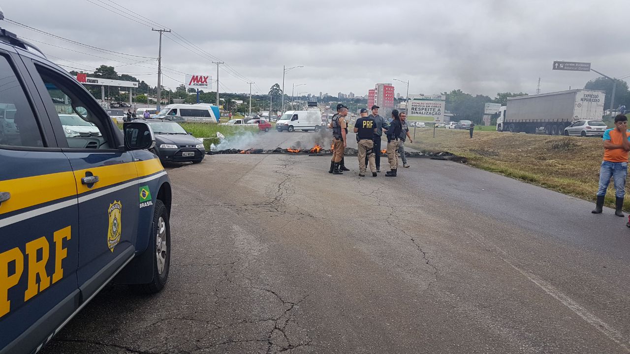 PRF aguarda a chegada dos Bombeiros para apagar os pneus após protesto na Linha Verde. | PRF /