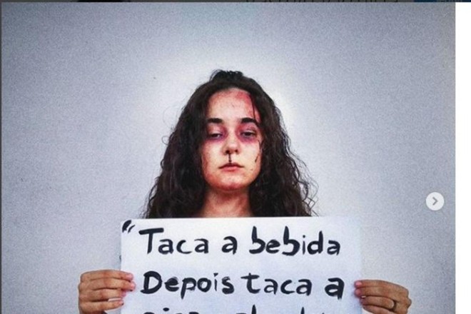 A artista Yasmin Formiga publicou uma foto na qual aparece machucada, carregando um cartaz com o trecho polêmico | Reprodução