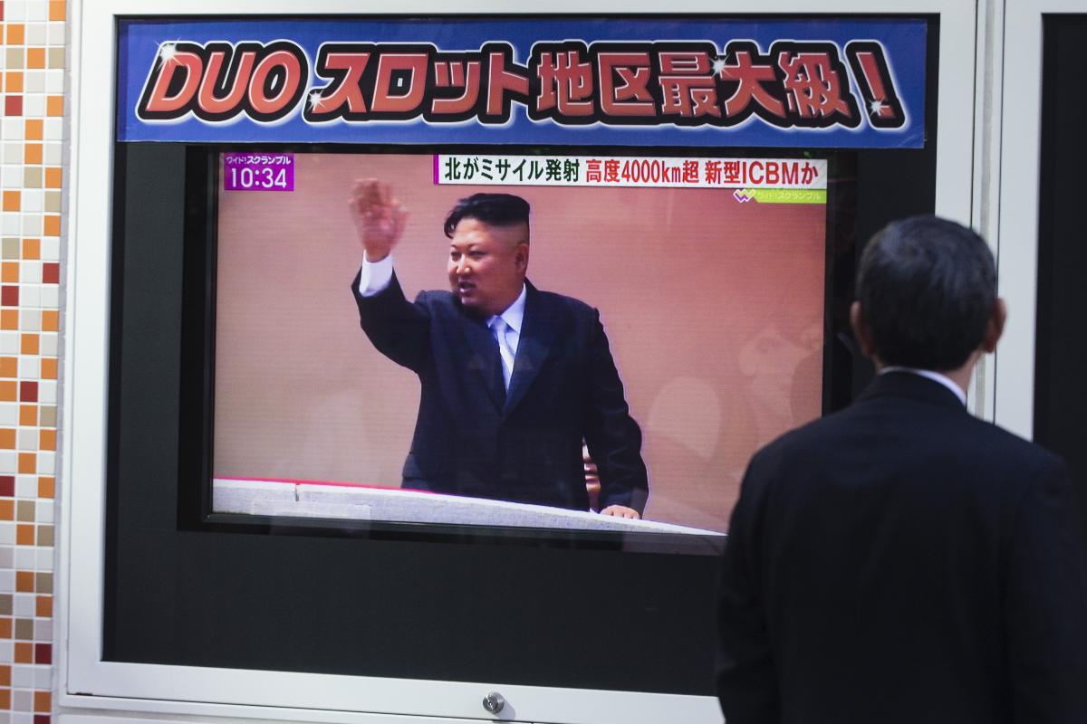 Pedestre em Tóquio vê transmissão do pronunciamento do ditador da Coréia do Norte, Kim Jong Un, durante um programa de notícias que informa sobre o lançamento de mísseis da Coréia do Norte em 29 de novembro de 2017. | Keith Bedford/Bloomberg