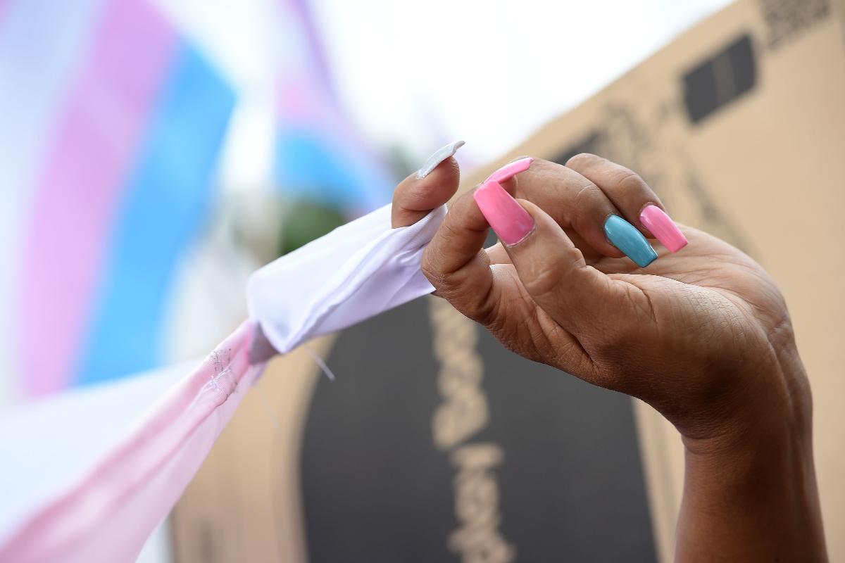 Detalhe da mão de uma manifestante com as unhas pintadas nas cores da comunidade transgênero, rosa e azul, durante a Parada Gay em Los Angeles em junho de 2017 | ROBYN BECKAFP