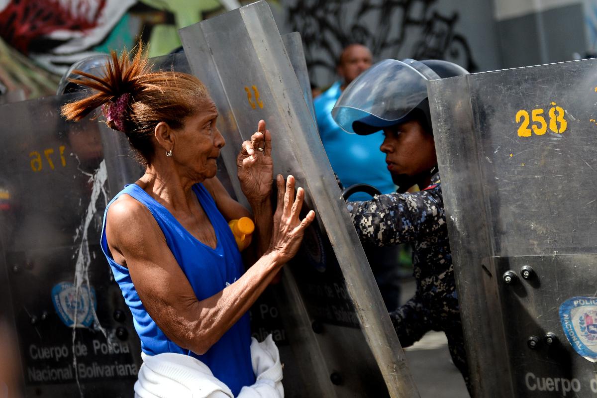 Mulher confronta a polícia durante protesto contra a falta de comida, em Caracas, em 28 de dezembro de 2017. | FEDERICO PARRA/AFP