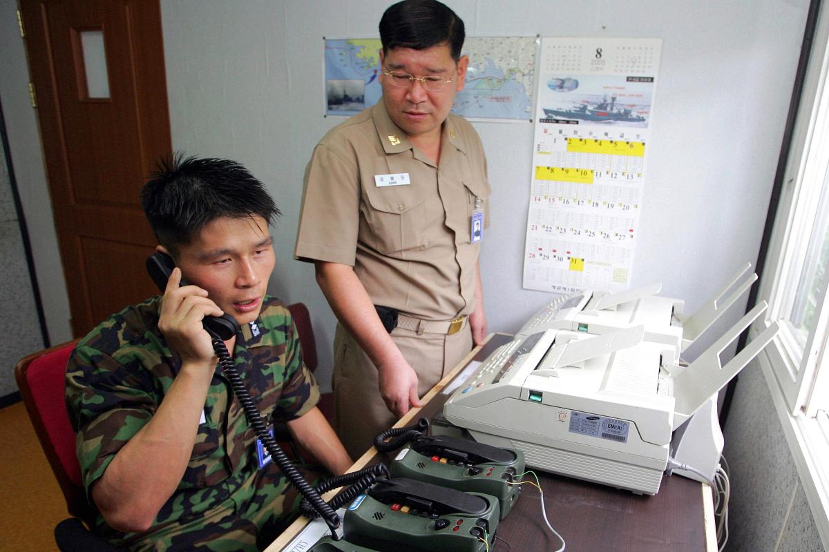 Tenente da Coreia do Sul Choi Don-Rim (E) se comunicando com a Coreia do Norte em uma ligação feita a partir do escritório militar próximo a Zona Desmilitarizada. | -
AFP