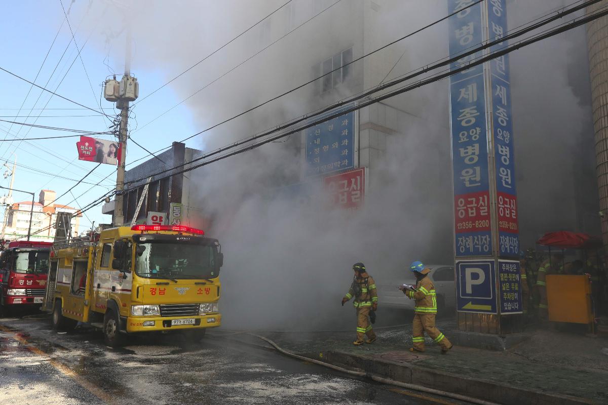 Bombeiros tentam apagar as chamas no prédio do hospital em meio a uma cortina de fumaça. | -AFP