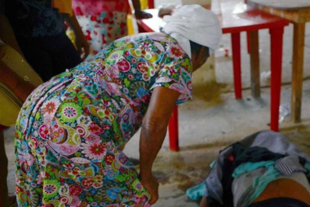 Um mulher olha para uma das vítimas fatais depois de um tiroteio na vila de La Concepcion, em Acapulco, México. | FRANCISCO ROBLESAFP PHOTO