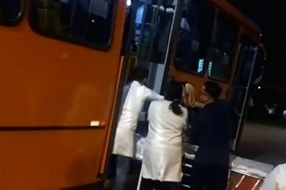 Agentes de saúde socorrem passageiro baleado: ônibus levou a vítima até unidade de saúde. | Colaboração/