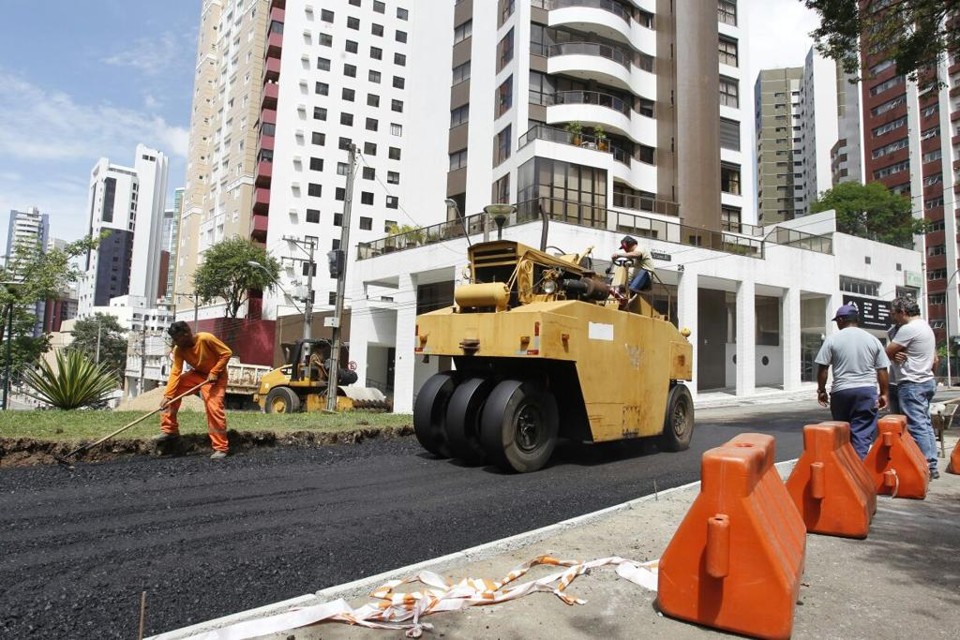 Operários trabalham na aplicação do asfalto no trecho onde o Libeirão fará o contorno na Praça do Japão. | Daniel Caron/Gazeta do Povo