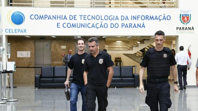 Policiais saindo com documentos da Celepar. | Aniele Nascimento/Gazeta do Povo