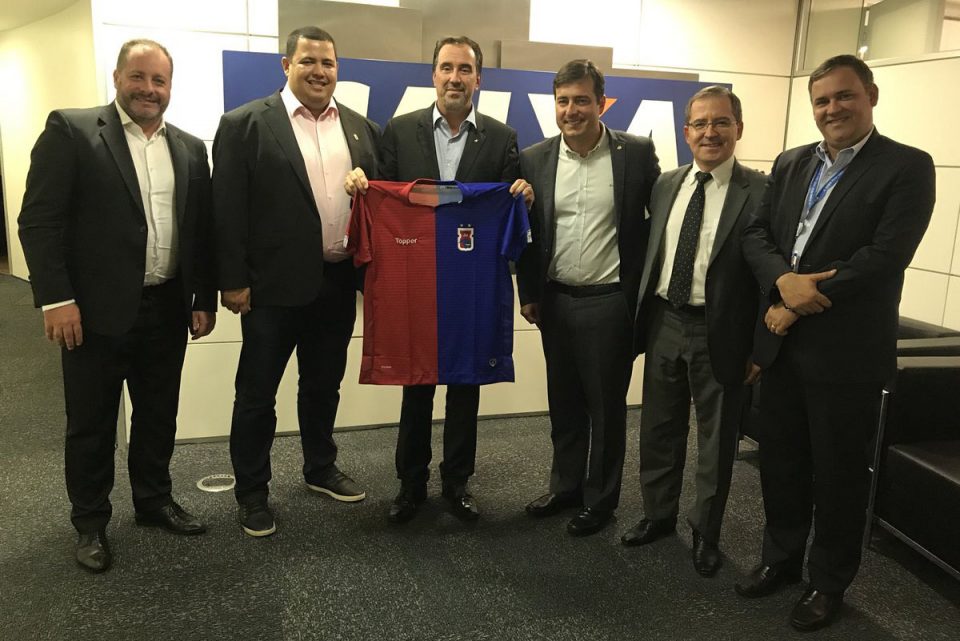 Leonardo Oliveira, presidente do Paraná, segundo da esquerda para a direita, e Gilberto Occhi, presidente da Caixa, segurando a camisa do Tricolor. | Reprodução Twitter