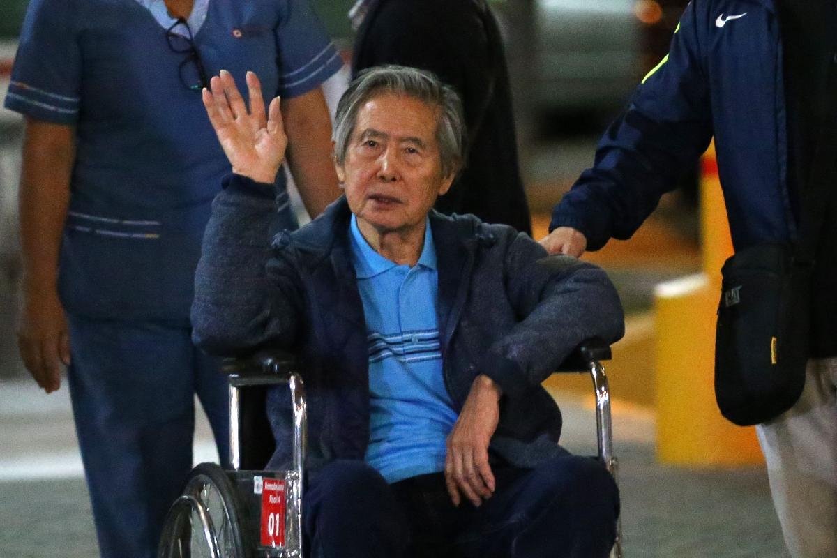 Enquanto deixa uma clínica em Lima, na qual estava hospitalizado, Alberto Fujimori acena para pessoas que o apoiam | LUKA GONZALES/AFP