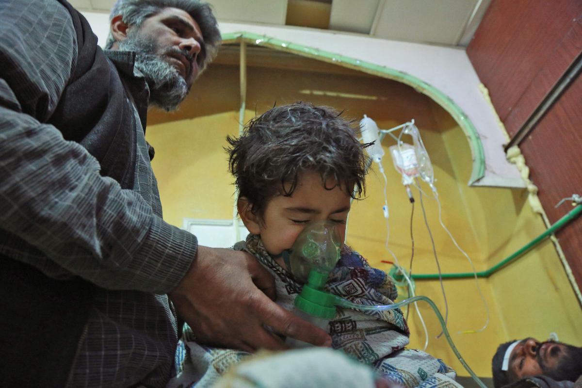 Crianças e adultos sírios receberam tratamento em decorrência de um suposto ataque químico, nos arredores da capital Damasco, em 25 de fevereiro | HAMZA AL-AJWEHAFP