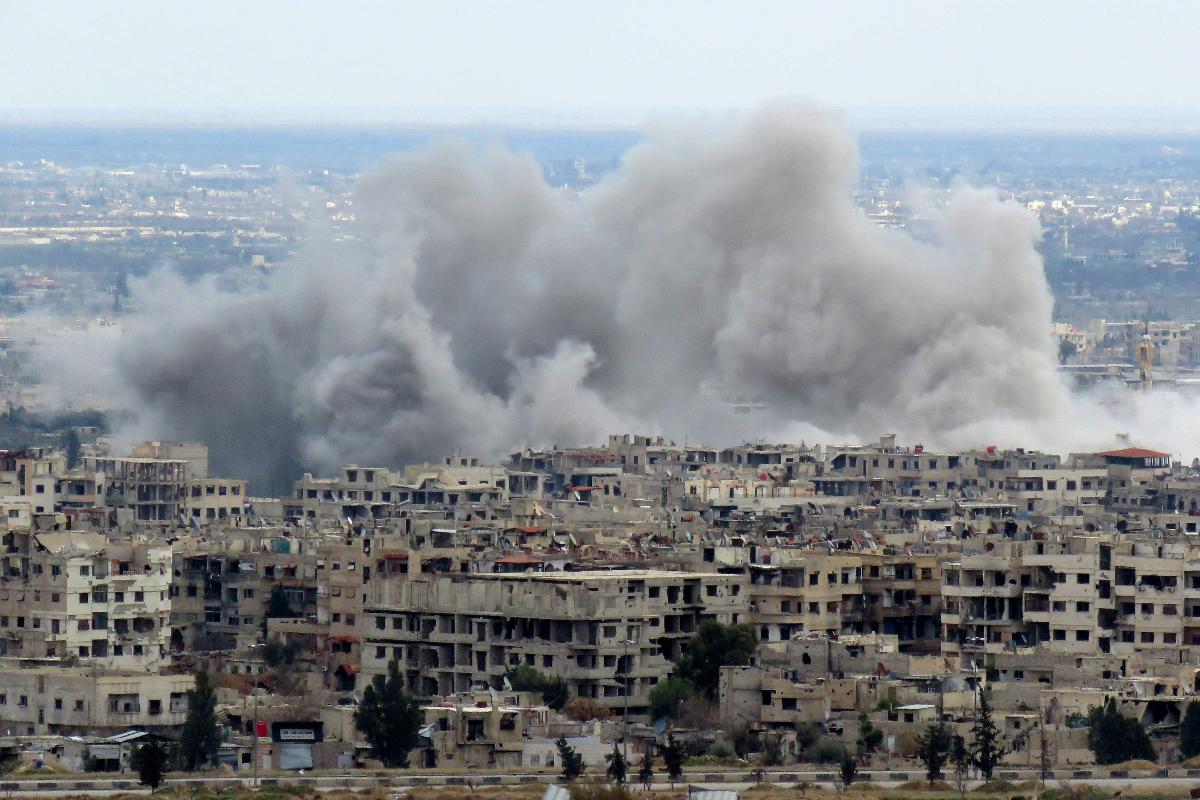 Vista geral de Damasco mostra uma grande cortina de fumaça cobrindo parte de Ghouta Oriental, após um ataque | STRINGERAFP