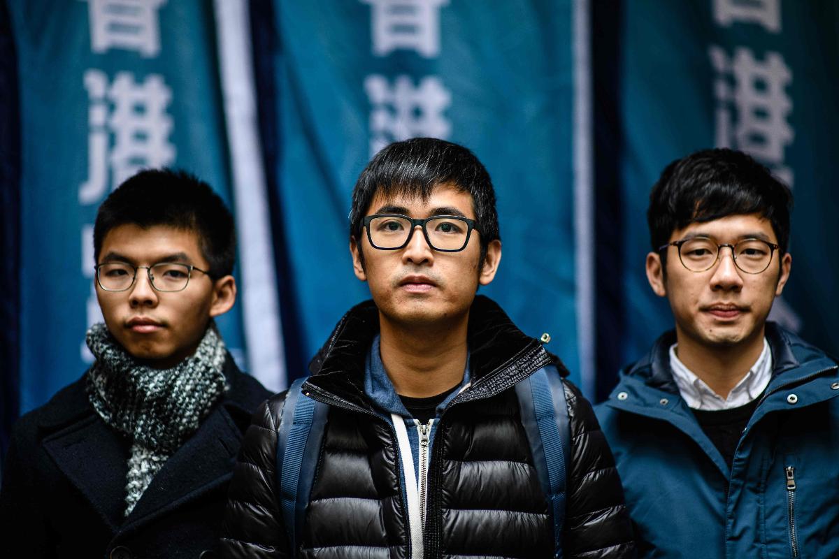 Joshua Wong, Nathan Law e Alex Chow, os principais líderes do movimento pró-democracia que ficou conhecido como movimento dos guarda-chuvas, no Tribunal de Hong Kong, em 6 de fevereiro de 2018 | ANTHONY WALLACE/AFP