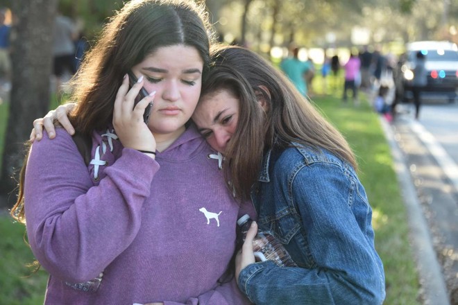 Alunas reagem após massacre na escola secundária Marjory Stoneman Douglas em Parkland, Flórida, cidade a cerca de 80 km ao norte de Miami, em 14 de fevereiro de 2018. | MICHELE EVE SANDBERG/AFP