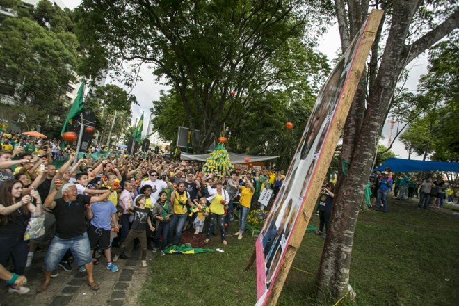 Manifestantes jogam tomates em fotos de políticos durante protesto em frente da Justiça Federal de Curitiba, em dezembro de 2016: Brasil ocupa 96ª posição em ranking de percepção da corrupção. | Marcelo Andrade/Gazeta do Povo