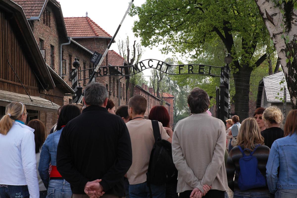 Grupo de visitantes em frente ao antigo campo de concentração nazista Auschwitz, na Polônia | Marcin PrzybylkoBloomberg