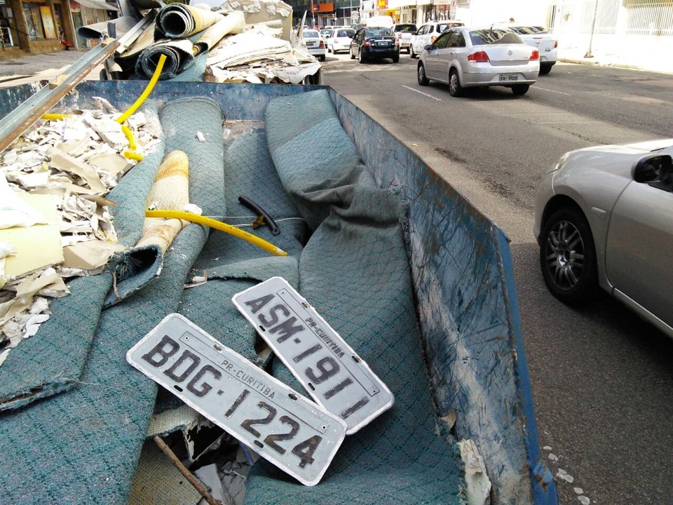 Placas que se desprenderam durante a enchente de quarta-feira (14) estao jogadas em caçamba na esquina da ruas Visconde de Nacar com Dr. Carlos de Carvalho, no Centro. | Aniele Nascimento/Gazeta do Povo