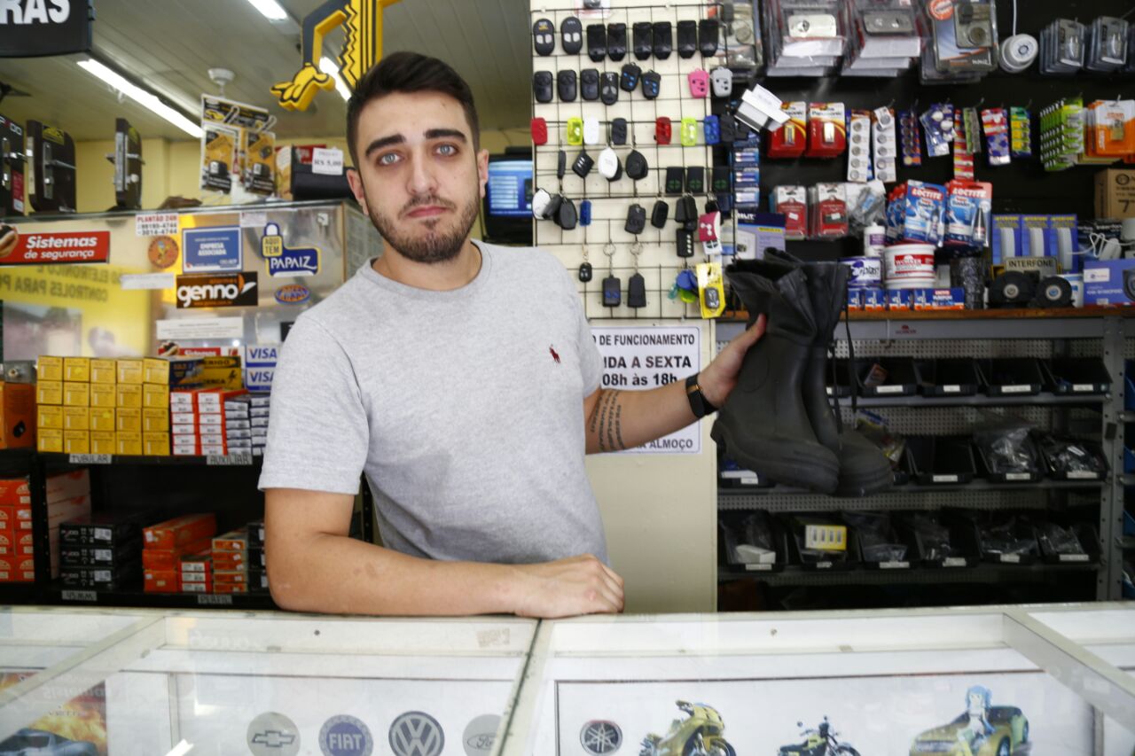 Chaveiro Fábio Moreto mantém um par de botas no balcão de seu comércio: a qualquer momento a água pode subir. | Aniele Nascimento/Gazeta do Povo