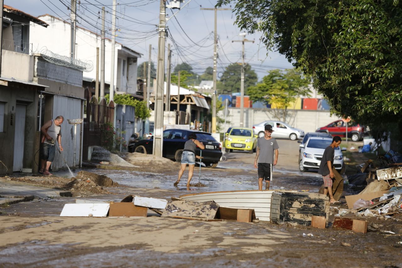 Moradores da CIC limpam as casas após a enchente de sábado. | Marco Charneski/Tribuna do Paraná
