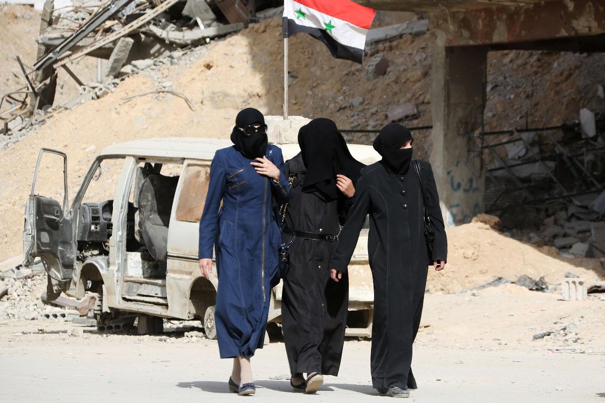 Mulheres sírias caminham pelas ruas de Douma, cidade nos arredores de Damasco. | Divulgação/AFP