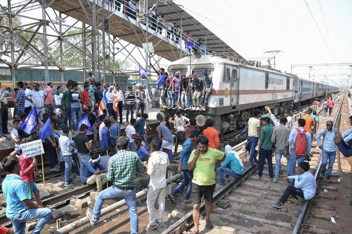 Membros do grupo indiano Dalit bloqueiam um trem em uma estação durante protestos contra uma decisão da Suprema Corte | -AFP