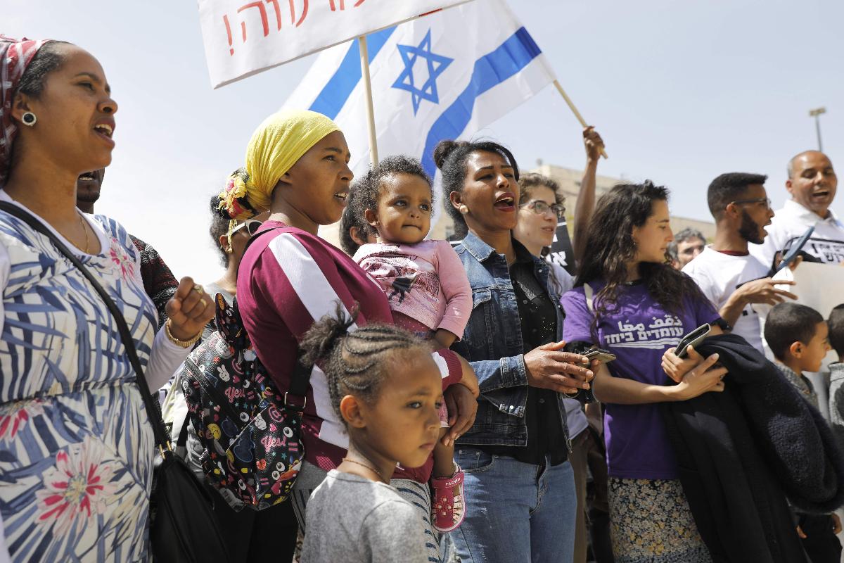 Imigrantes africanos e israelenses protestam em frente ao gabinete do primeiro-ministro de Israel Benjamin Netanyahu | MENAHEM KAHANA/AFP