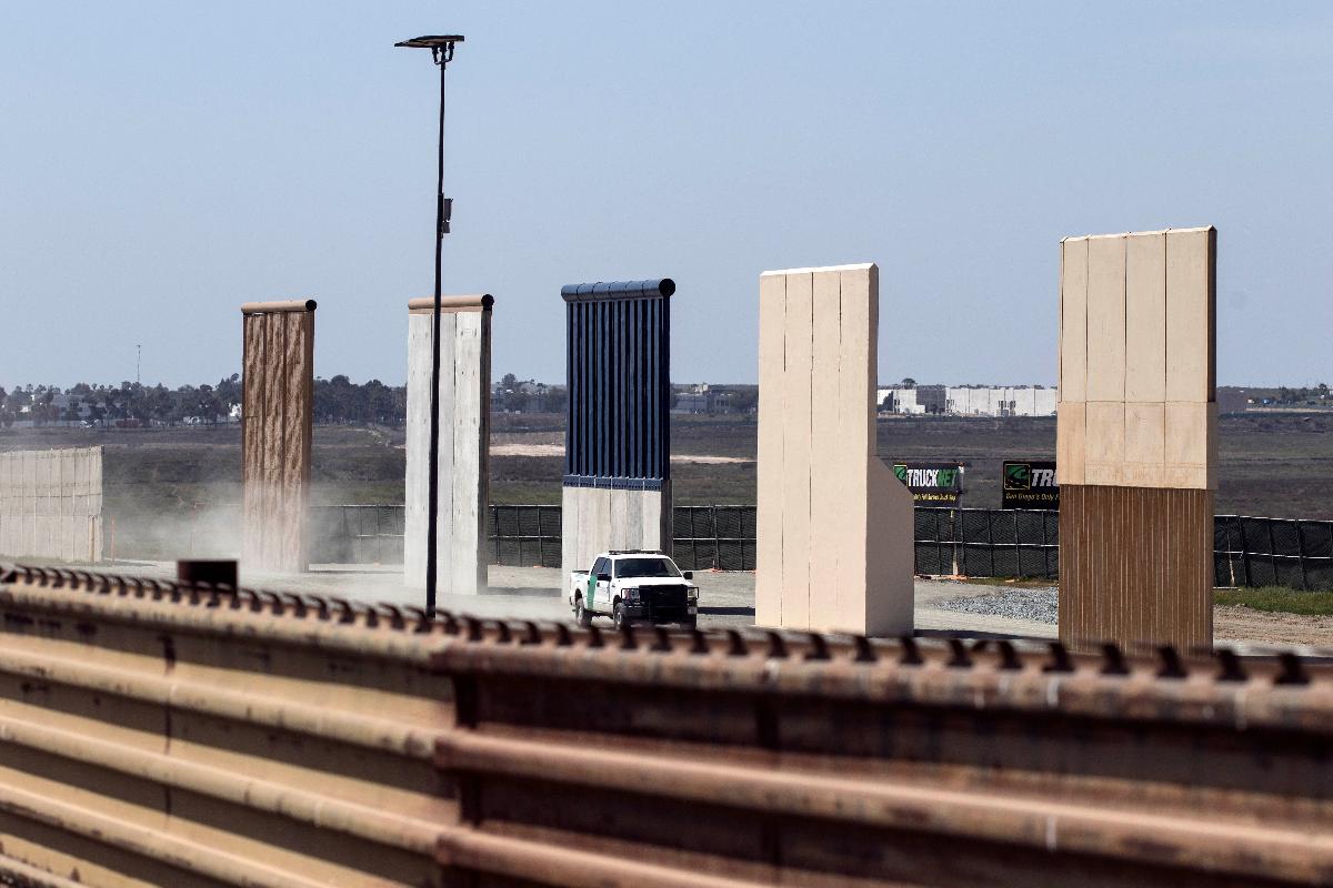 Um veículo de patrulha da fronteira dos EUA é visto ao lado dos protótipos do muro entre EUA e México em Tijuana, no noroeste do México, em 3 de abril de 2018. O presidente Donald Trump prometeu nesta terça-feira enviar militares para garantir a fronteira sul dos EUA. | GUILLERMO ARIASAFP