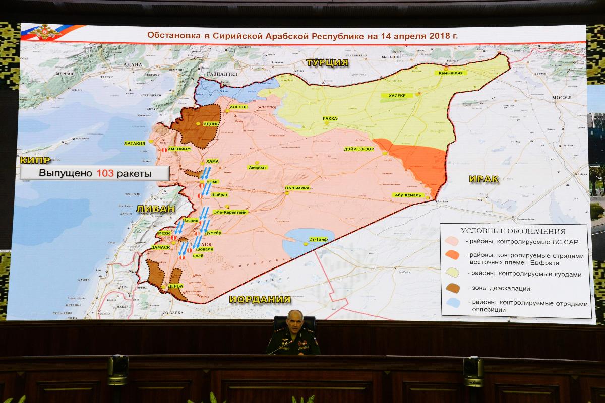 O oficial militar russo Sergei Rudskoi senta-se abaixo de um mapa da Síria, exibido durante uma reunião na sede do Ministério da Defesa russo em Moscou, após EUA, França e Reino Unido terem atacado a Síria | KIRILL KUDRYAVTSEV/AFP